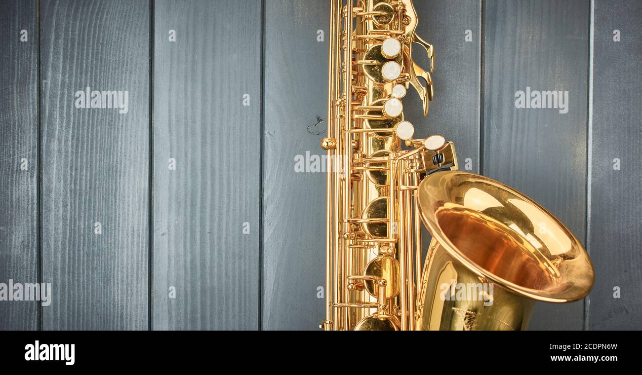 Notez les touches et la cloche d'un saxophone ténor doré brillant sur bois gris Banque D'Images