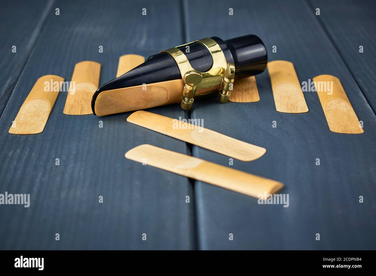 Roseaux de rechange et embout buccal saxophone avec pince et réglage doré vis sur table en bois gris Banque D'Images