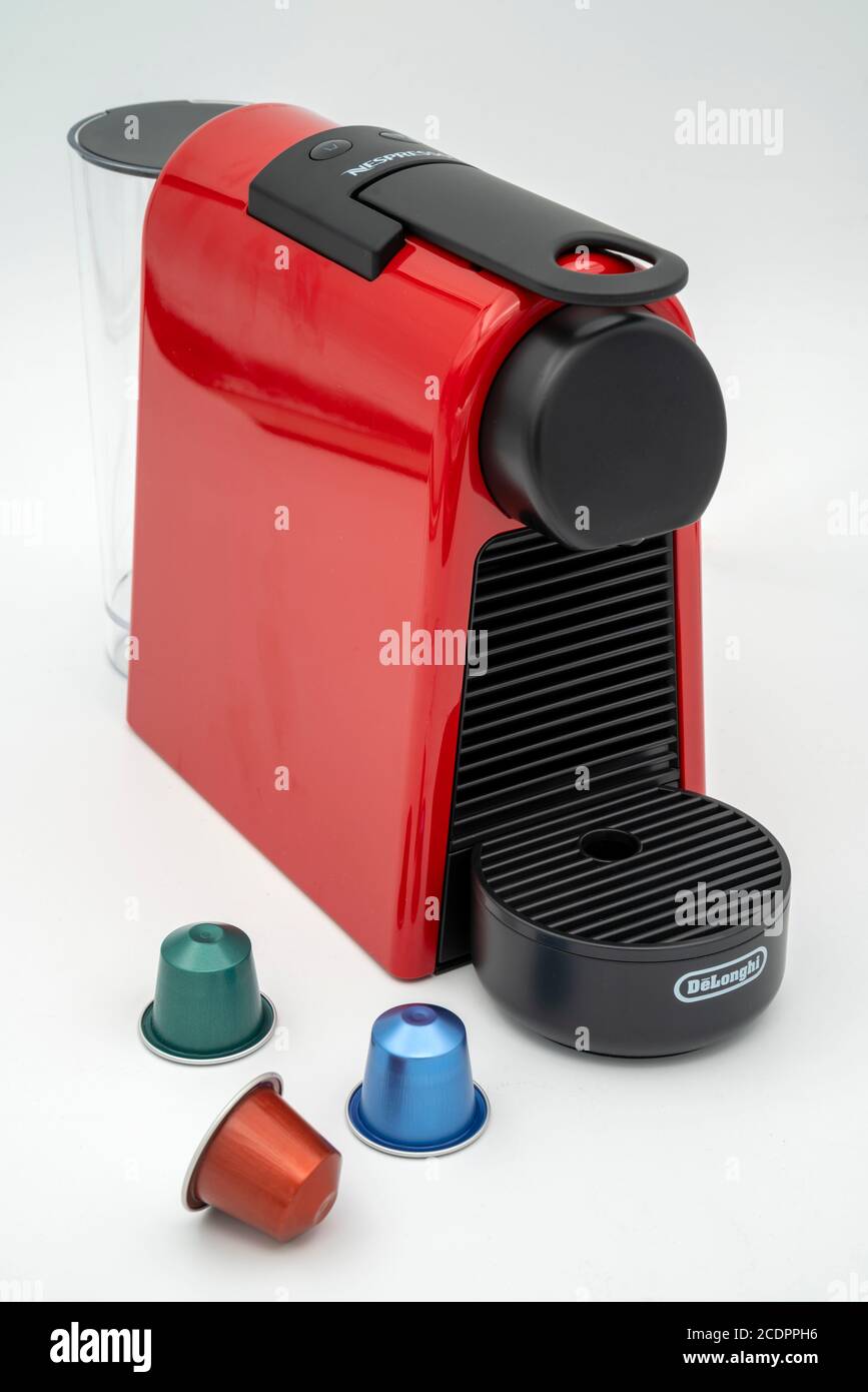 Machine à café Mini Nespresso Delonghi Essenza rouge avec capsules coupées isolé sur fond blanc Banque D'Images