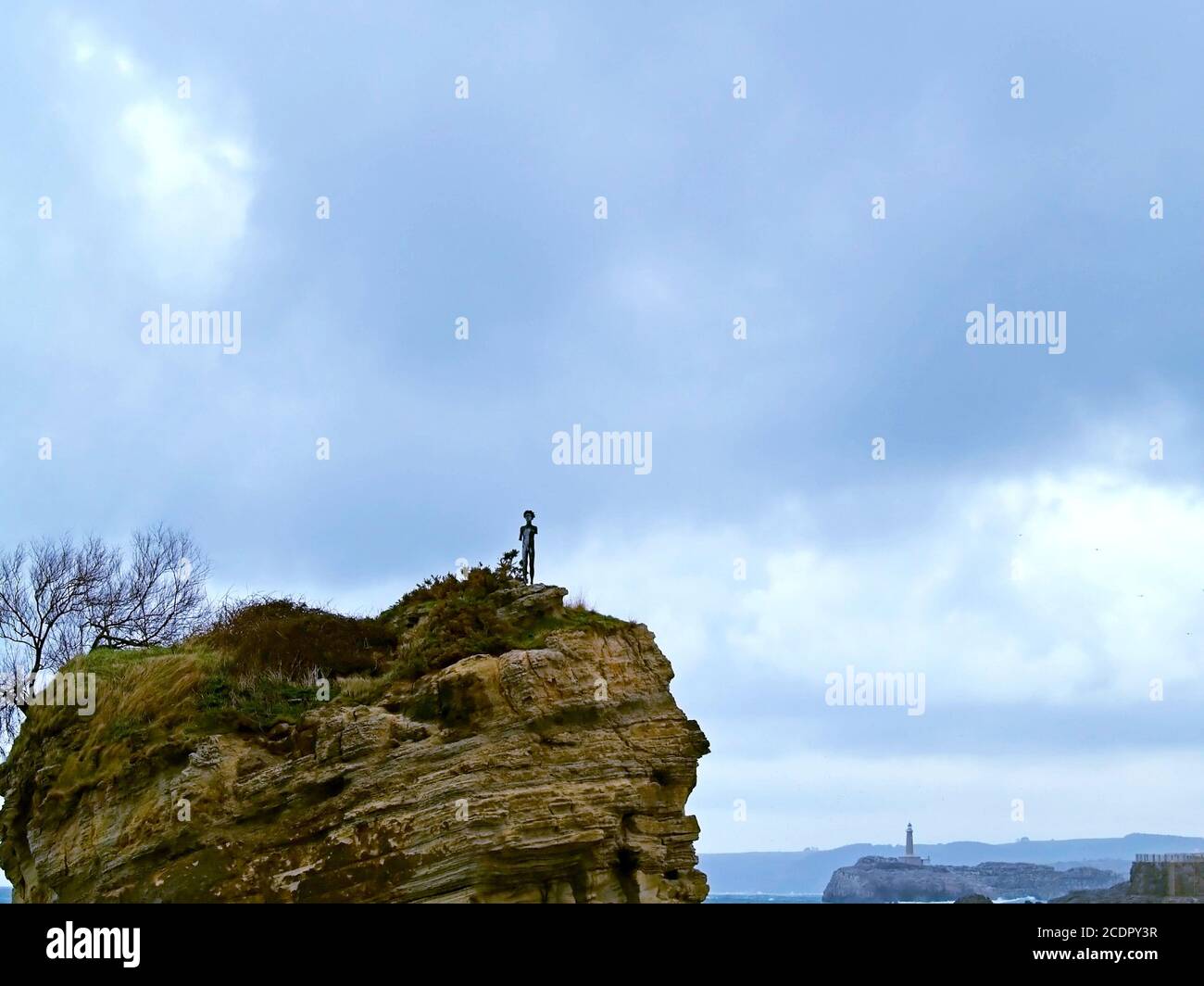 Statue d'un garçon sur un rocher dans la mer Banque D'Images