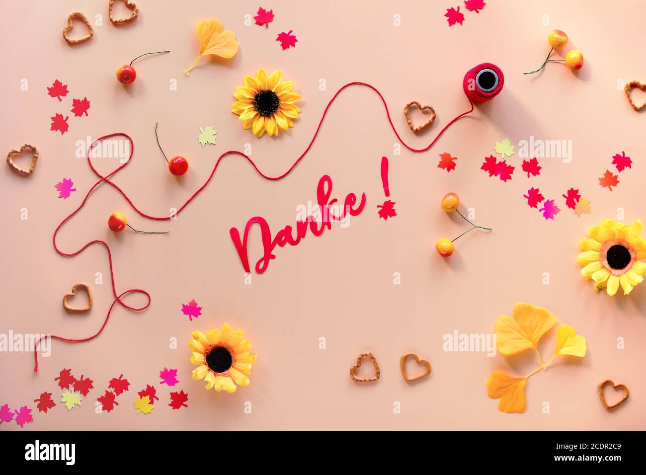Danke signifie Merci en allemand. Décorations d'automne - fleurs jaunes, feuilles de gingko orange, confetti de feuilles d'érable, corde et forme de coeur pré Banque D'Images