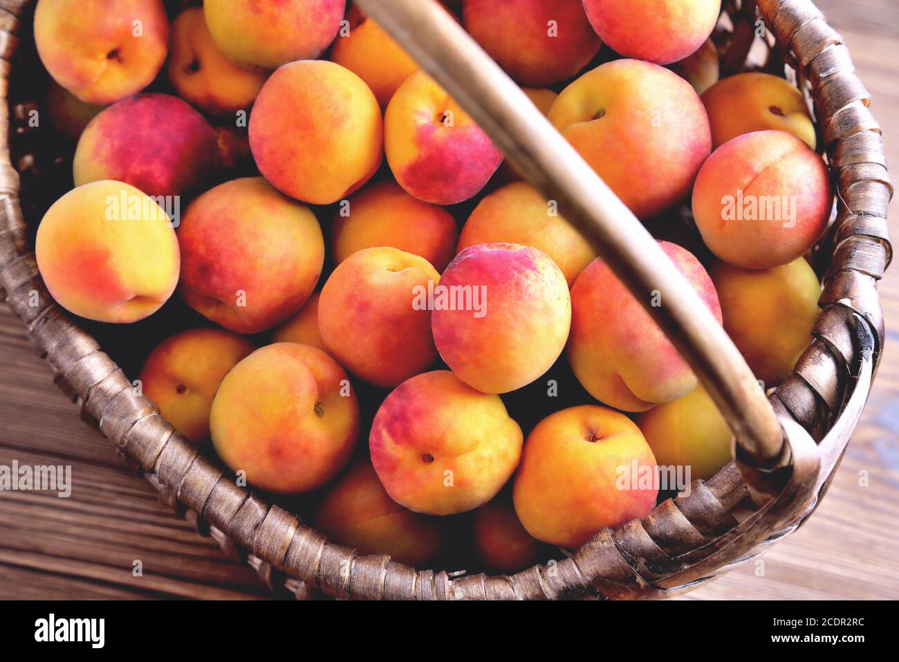 Abricots mûrs naturels dans un panier en osier gros plan vue Banque D'Images