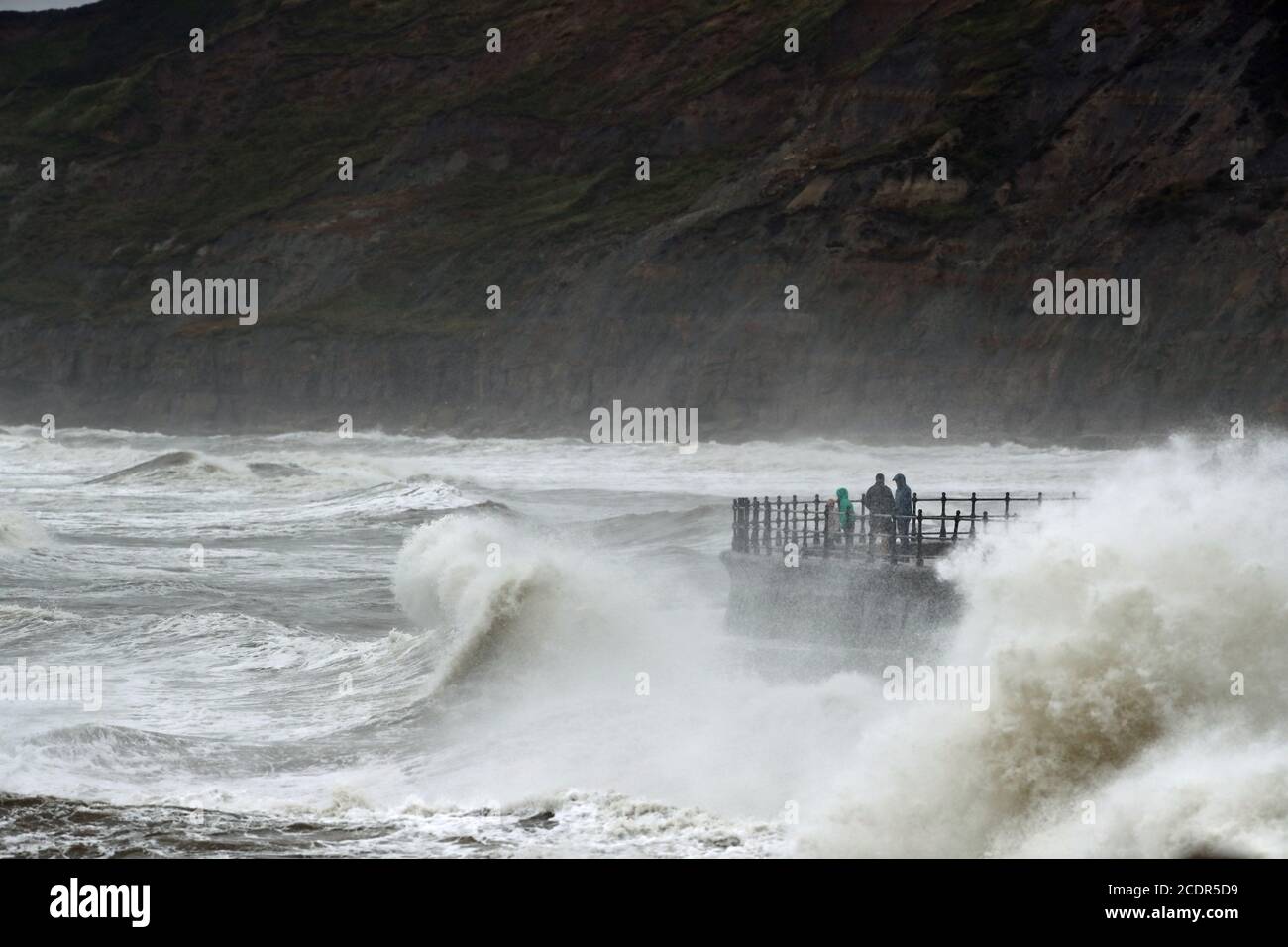 Les personnes qui marchent le long du front de mer venteux à Scarborough, dans le North Yorkshire. Date de la photo: Samedi 29 août 2020. Les prévisionnistes prévoient que ce lundi férié pourrait être le plus froid jamais enregistré pour certaines parties du Royaume-Uni, car les températures devraient être bien inférieures à la moyenne pour la période de l'année. Voir l'histoire de PA MÉTÉO orages. Le crédit photo devrait se lire comme suit : Danny Lawson/PA Wire Banque D'Images