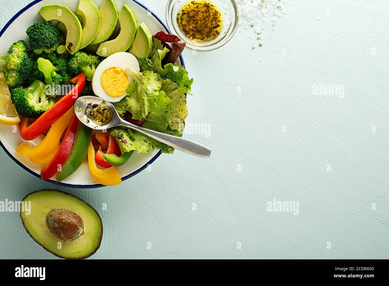 Repas de salade sain avec œufs, avocat et légumes frais mélangés sur fond bleu vue de dessus. Concept de repas sain Banque D'Images