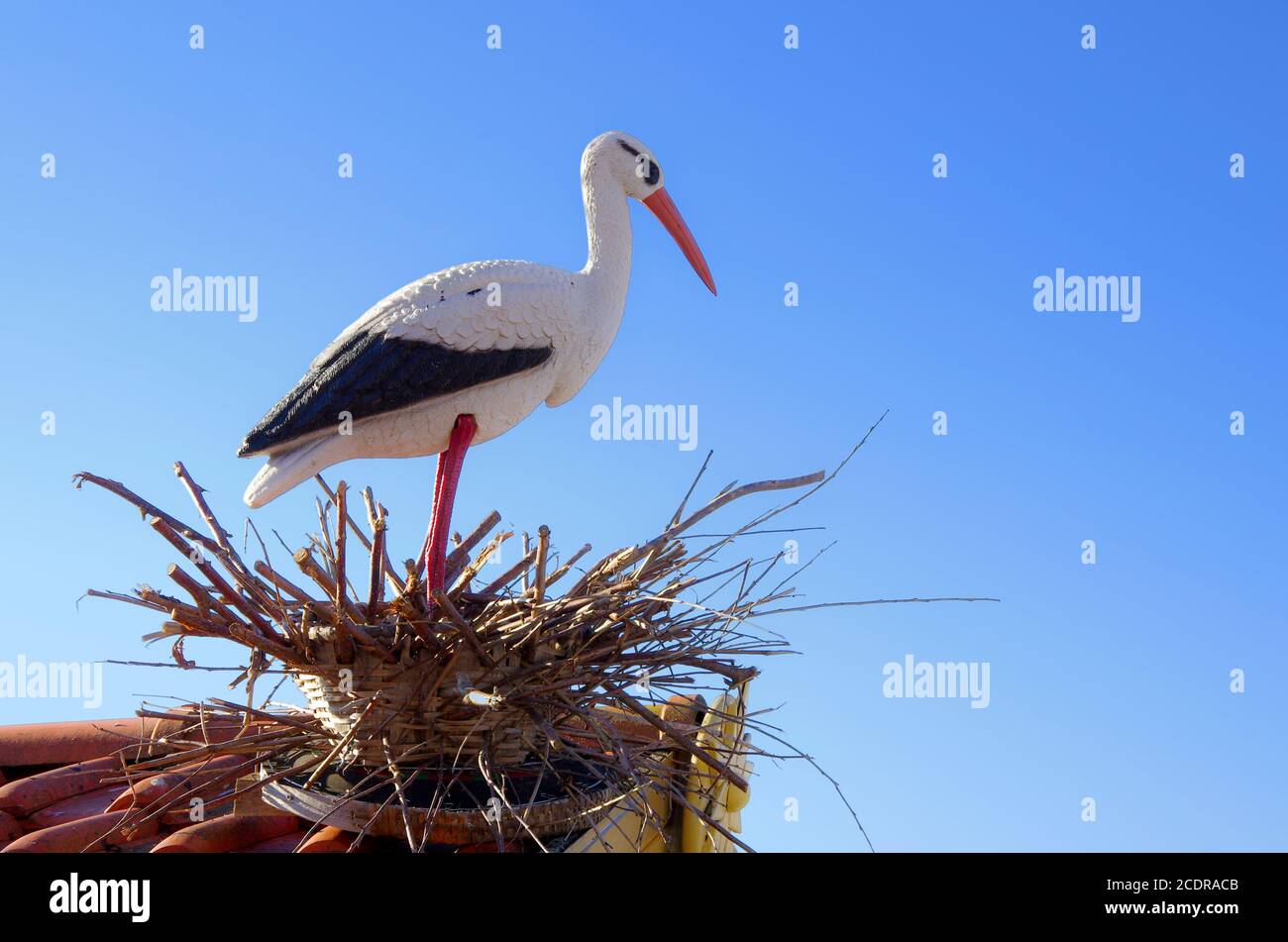 Sculpture en plastique d'une cigogne en plastique dans un nid. Banque D'Images
