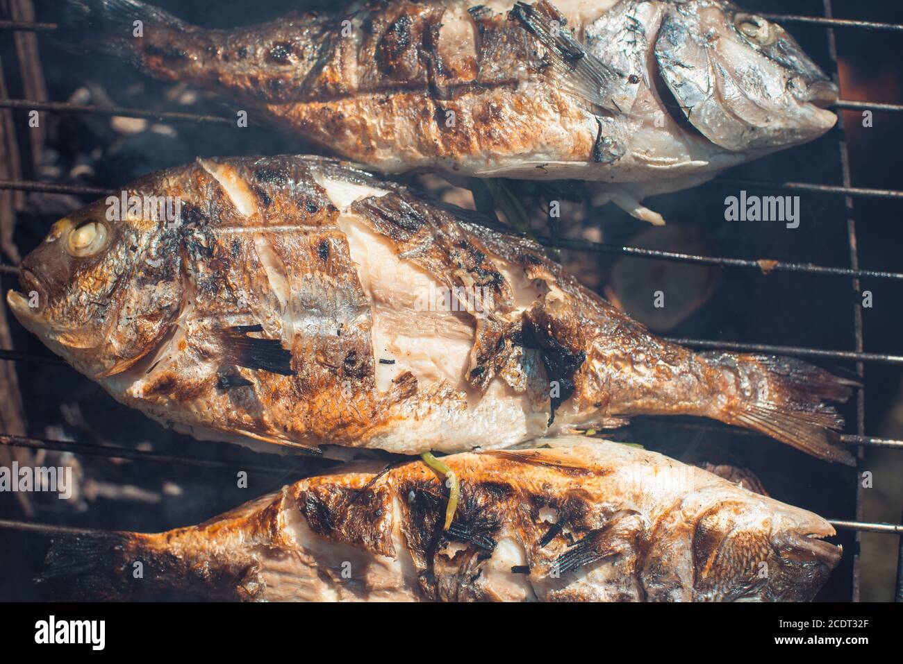 Les poissons grillés au citron sur la grille de barbecue dans le jardin en été Banque D'Images