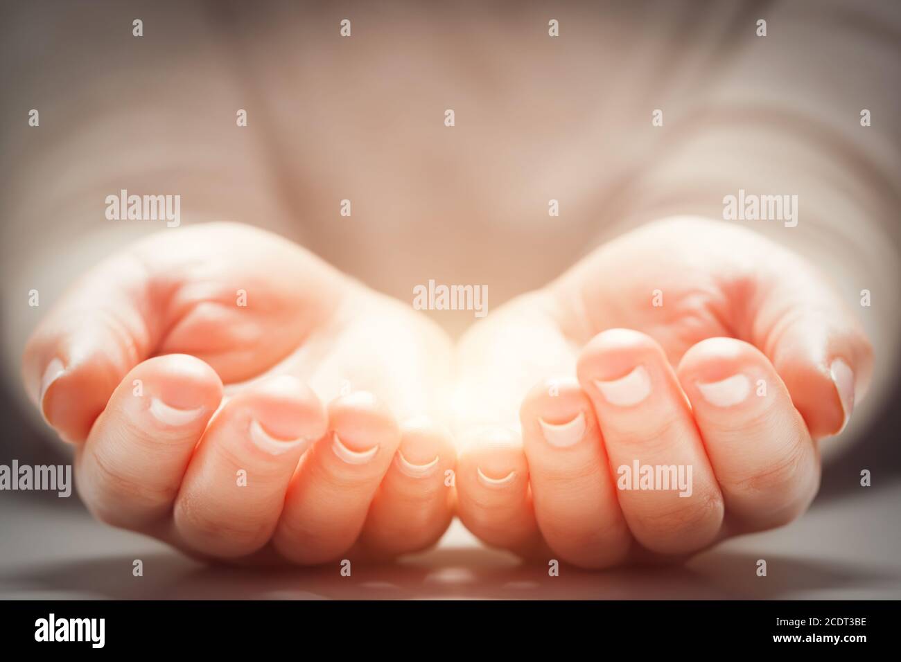 Lumière dans les mains de femme#39;s. Concepts de partage, de don, de nouvelle vie Banque D'Images