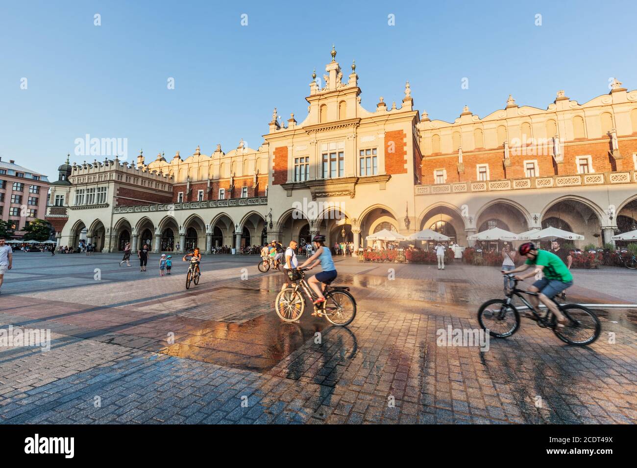 Les gens qui font du vélo sur la place principale du marché de Cracovie, en Pologne Banque D'Images