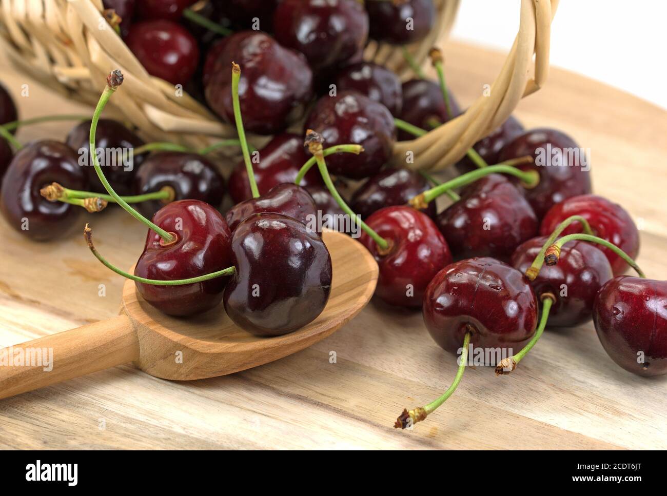 Cerises douces sur une cuillère en bois Banque D'Images