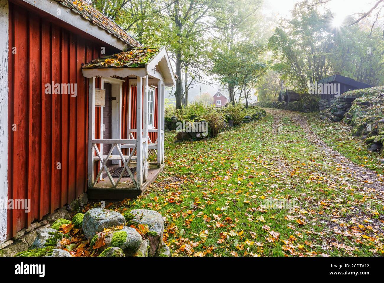 Chalet rouge avec une véranda dans un paysage rural la chute Banque D'Images