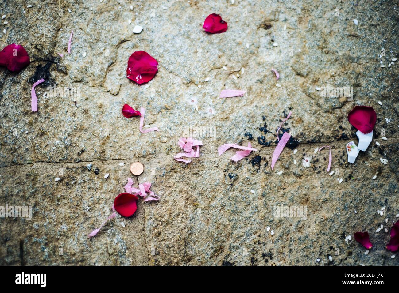 fond en pierre avec une pièce de monnaie aux pétales de rose et du papier de couleur rose threads Banque D'Images