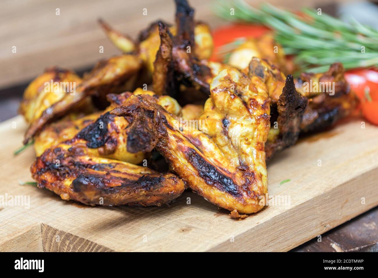 Ailes de poulet grillé sur une surface en chêne clair. Banque D'Images