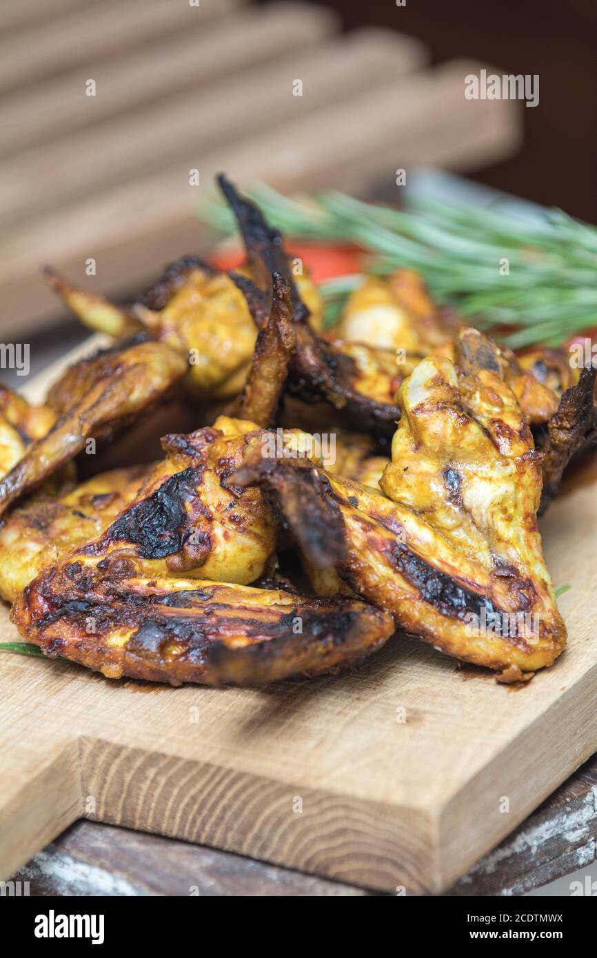 Ailes de poulet grillé sur une surface en chêne clair. Banque D'Images