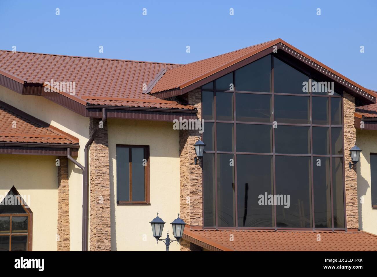 Bâtiment avec des murs jaunes et un toit rouge-brun. Les matériaux modernes de finition et de toiture. Banque D'Images