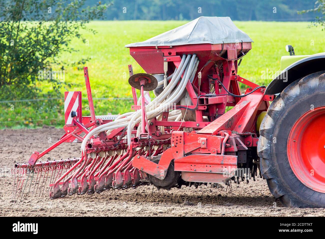 Tracteur avec des machines agricoles sur les terres agricoles Banque D'Images