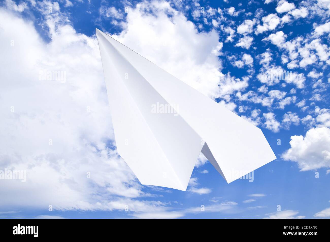 Avion de Papier blanc dans un ciel bleu avec des nuages. Le symbole du message dans le messager Banque D'Images