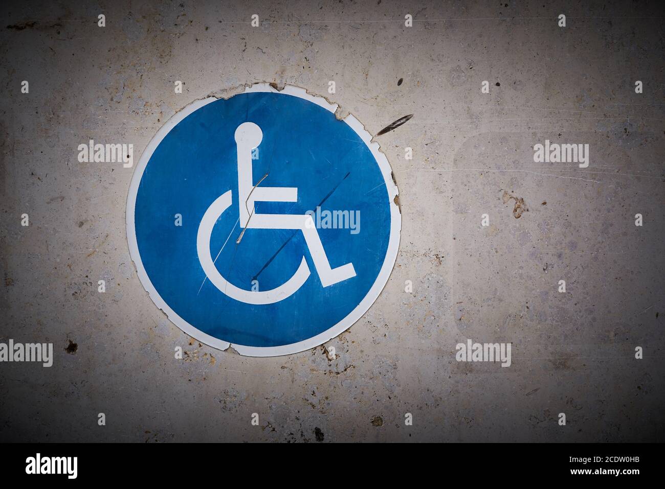 Symbole d'une place de stationnement pour handicapés sur le mur de un parking couvert Banque D'Images