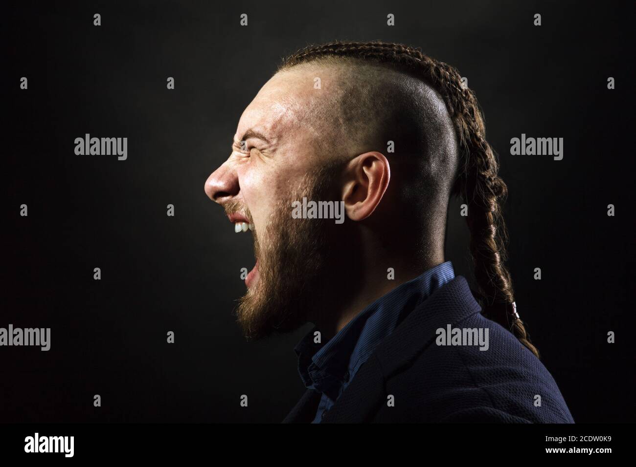 L'homme avec des dreadlocks cris de rage, ressemble à un viking, coupe Iroquois Banque D'Images