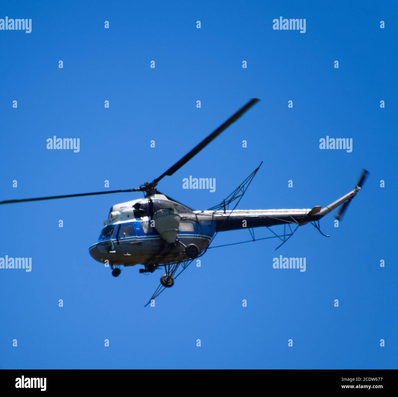 Un hélicoptère de l'aviation agricole vole dans le ciel bleu. Banque D'Images