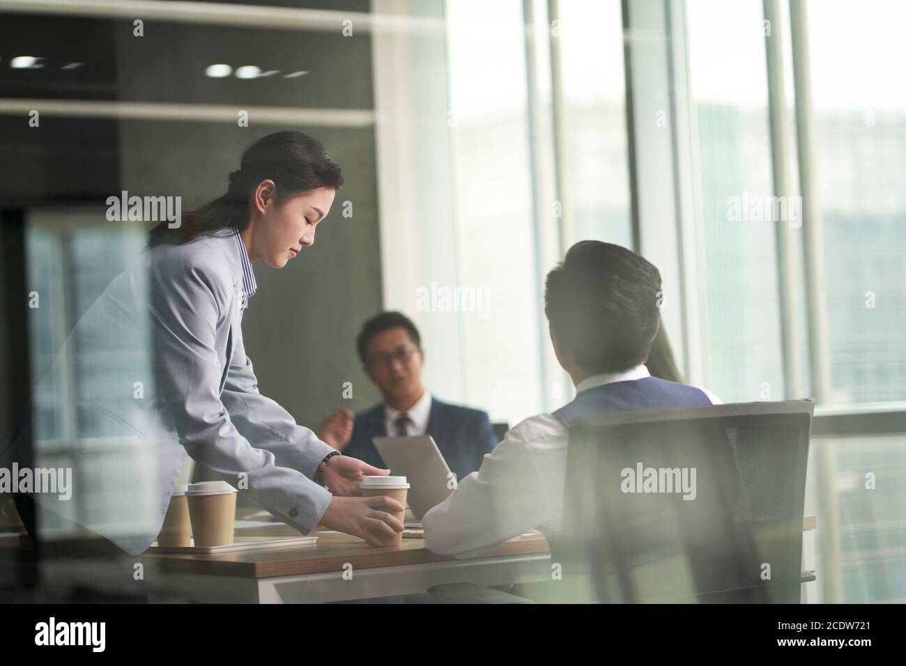 photo en verre d'un jeune stagiaire asiatique apportant du café pour les réunions d'affaires au bureau Banque D'Images