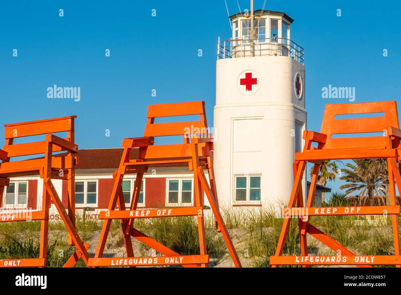 Chaises de sauveteurs sur la plage en face du bâtiment du corps de sauvetage volontaire de la Croix-Rouge américaine à Jacksonville Beach, Floride. (ÉTATS-UNIS) Banque D'Images