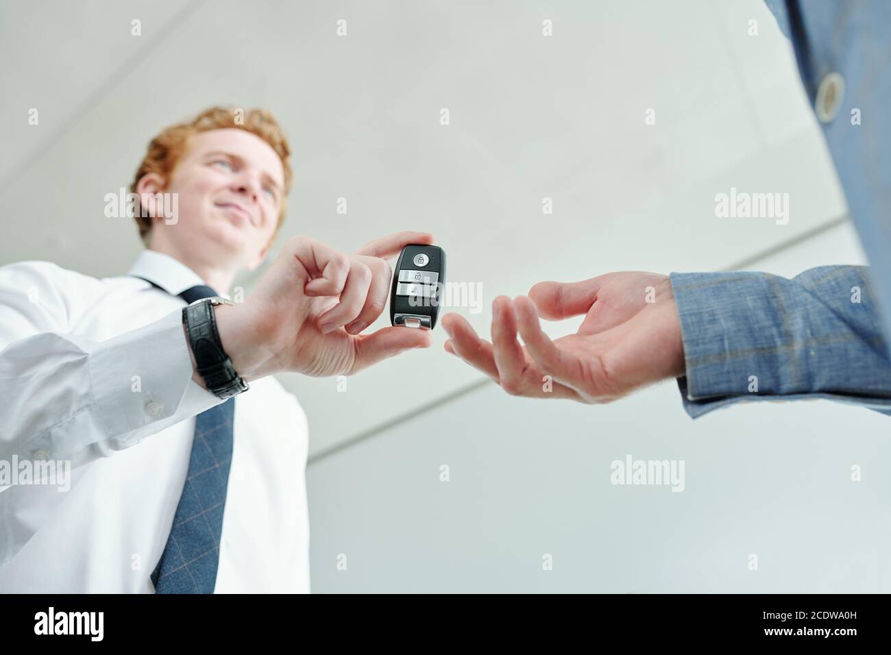 Main de l'acheteur de sexe masculin qui va prendre l'alarme de télécommande système de nouvelle voiture Banque D'Images