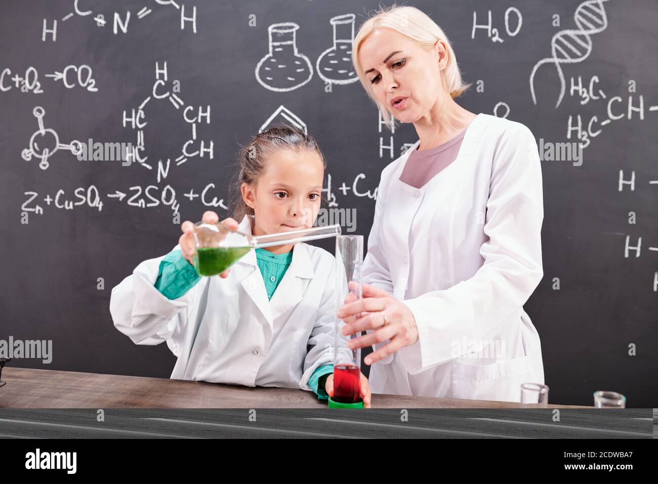 Blonde confiant professeur de chimie regardant l'école en blancoat Banque D'Images