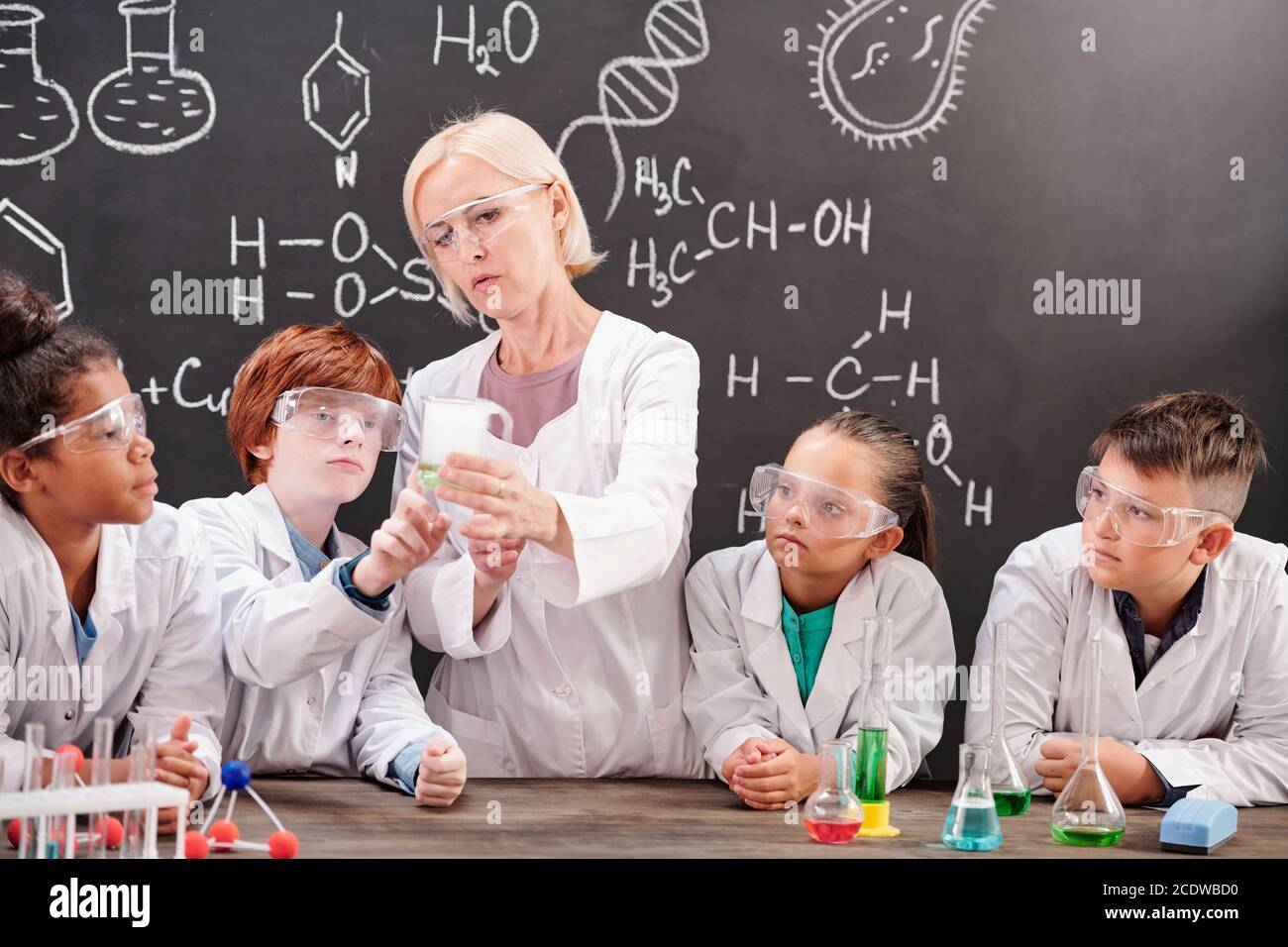 Professeur de chimie en blancoat montrant le mélange de deux produits chimiques substances Banque D'Images