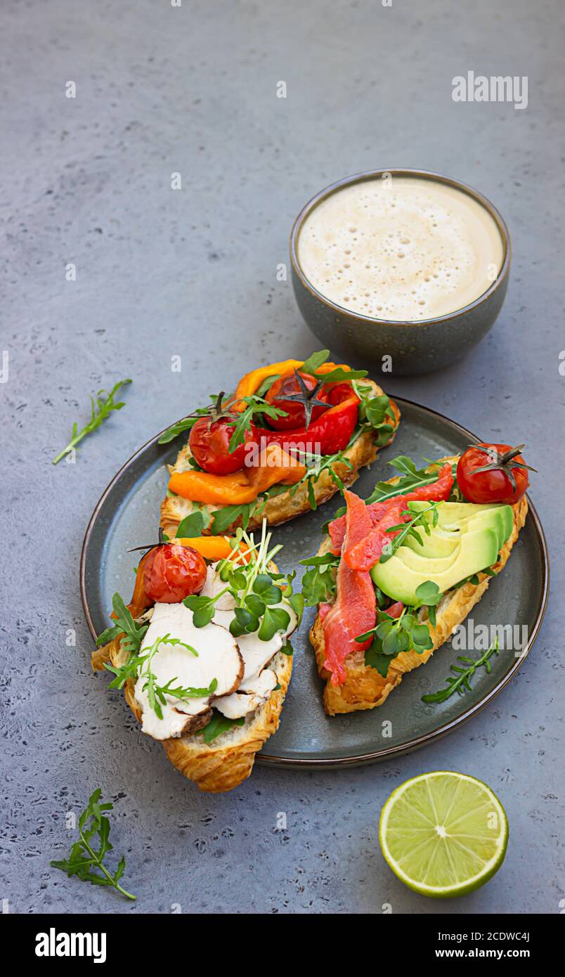 Petit Dejeuner Ou Dejeuner Avec Cafe Et Differents Croissants Avec Poivre Grille Tomates Saumon Fume Dinde Avocat Et Arugula Servis Avec Humour Photo Stock Alamy