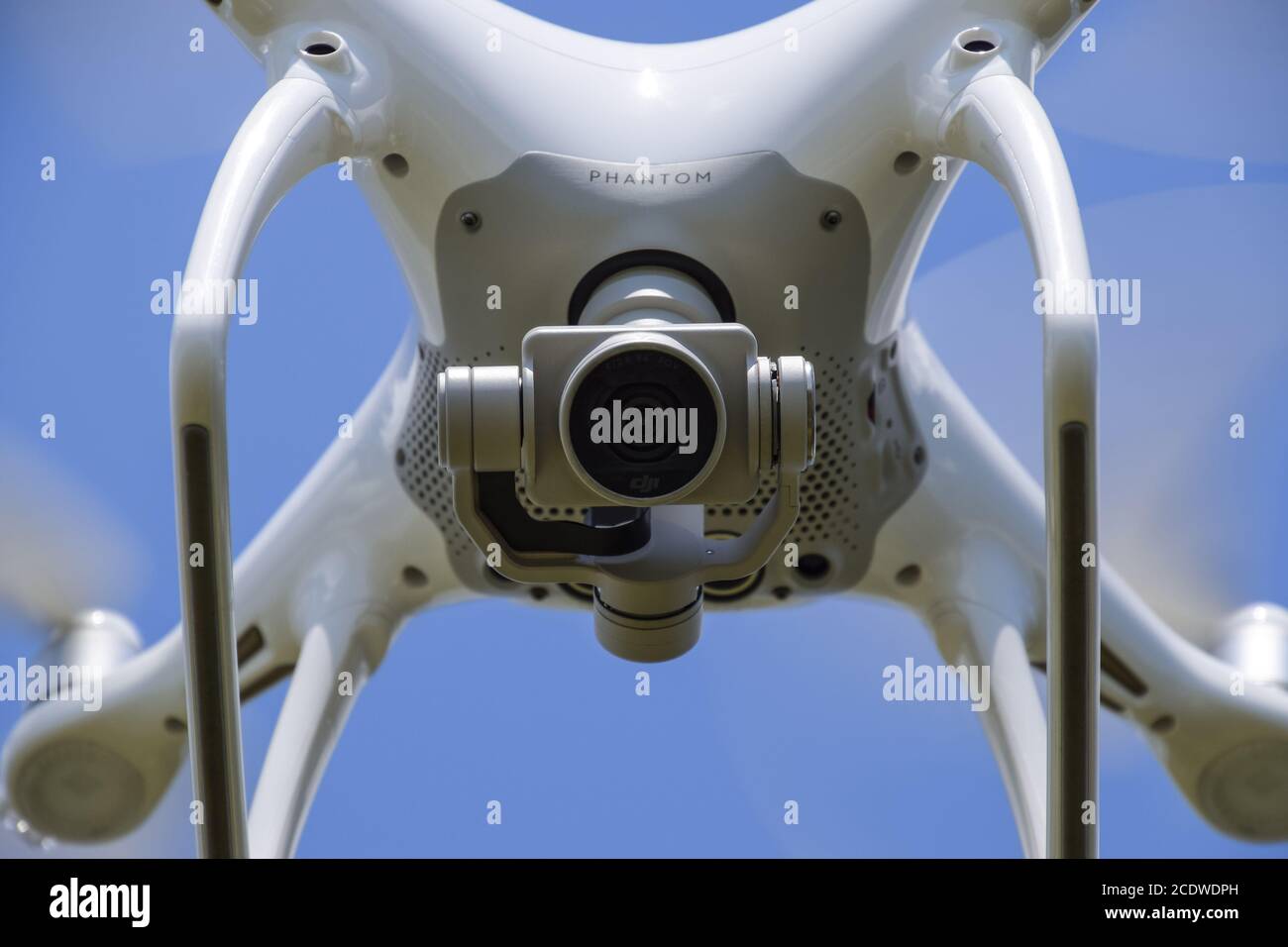 Drone DJI Phantom 4 en vol. Quadrocopter contre le ciel bleu avec des nuages blancs. Le vol de l'hélico dans le ciel. Banque D'Images