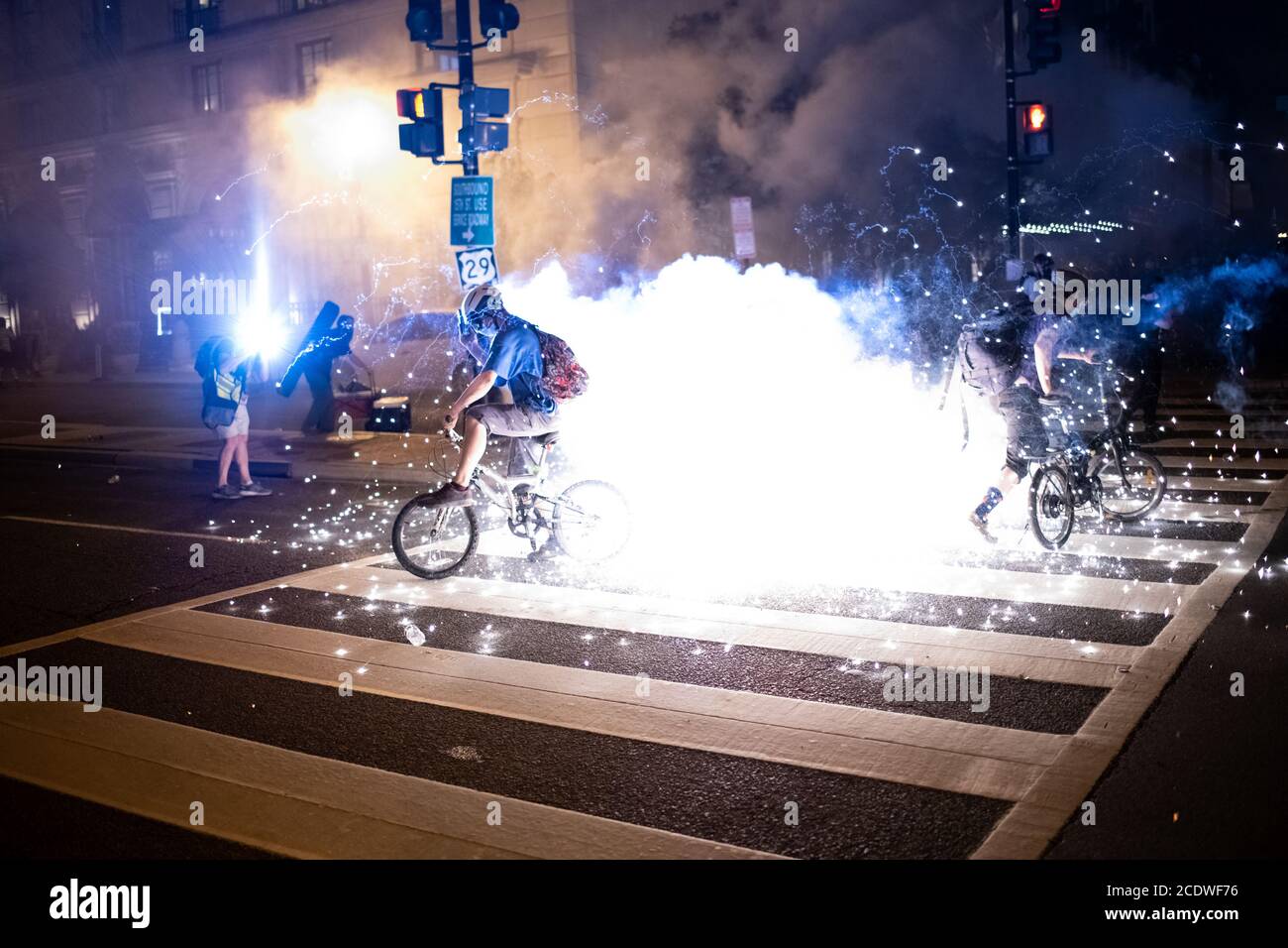 Une munition explose à côté des manifestants sur des vélos près de Black Lives Matter Plaza à Washington, DC, le 29 août 2020 dans le contexte de la pandémie du coronavirus. À la fin d'une semaine de manifestations qui ont débuté après la fusillade de de Jacob Blake dans le Wisconsin, puis qui ont continué par la Convention nationale républicaine, et ont abouti à l'engagement Mars: Le vendredi, samedi, nous avons fait des marches de protestation émotionnelles qui se sont terminées par une violente répression policière sur Black Lives Matter Plaza tard dans la nuit. (Graeme Sloan/Sipa USA) Banque D'Images
