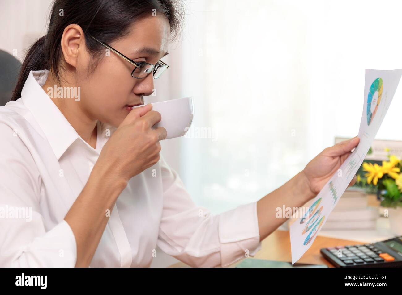 Gros plan femmes d'affaires asiatiques travaillant à domicile graphique de rapport d'analyse. Les gens d'affaires qui cherchent un plan de travail sont à portée de main. Banque D'Images