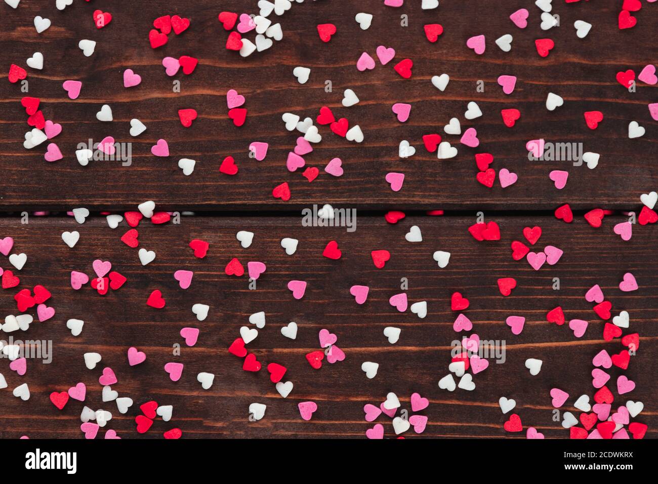 rouge, rose et sucre blanc saupoudrer les coeurs sur une table en bois comme un fond, la décoration pour le gâteau et la boulangerie dans le style rustique, les valentines et le jour de mariage Banque D'Images