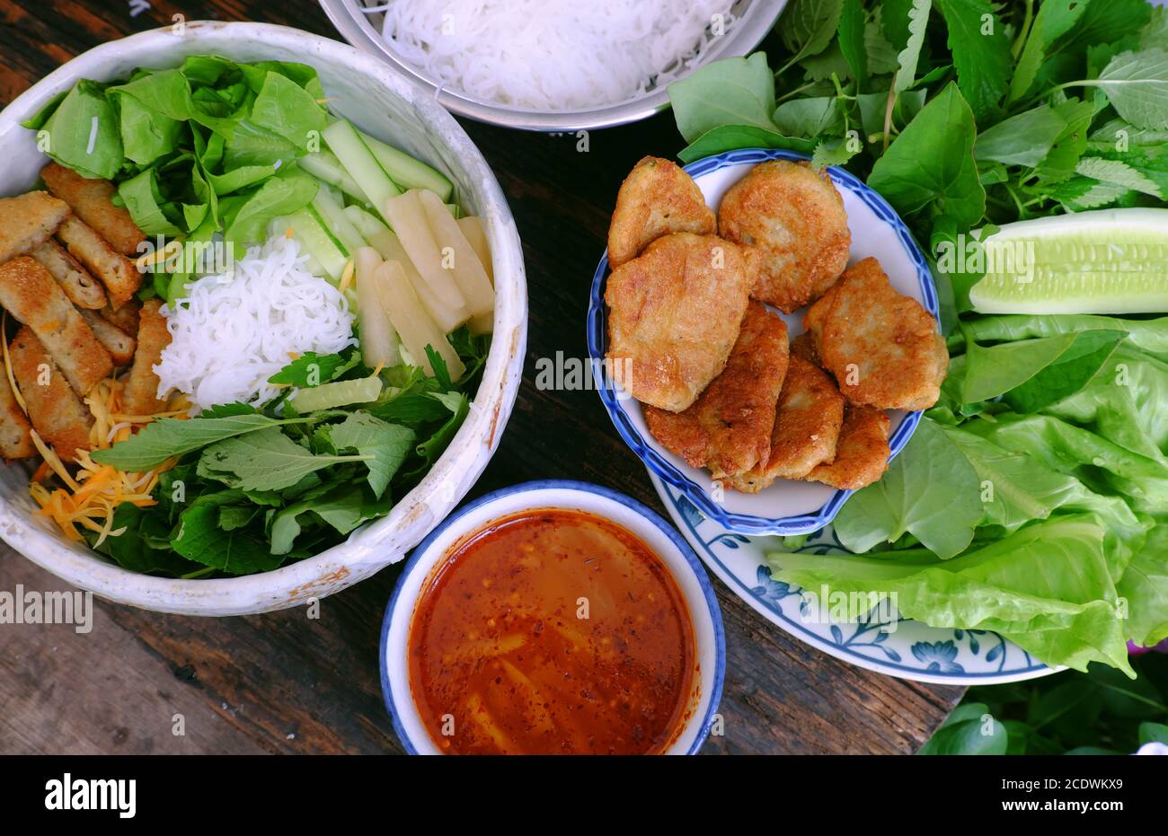 Repas végétarien vietnamien pour le petit déjeuner avec menu de régime, bol de nouilles avec tartes aux champignons frites, salade, sauce à tremper, nourriture végétarienne bonne pour la santé Banque D'Images