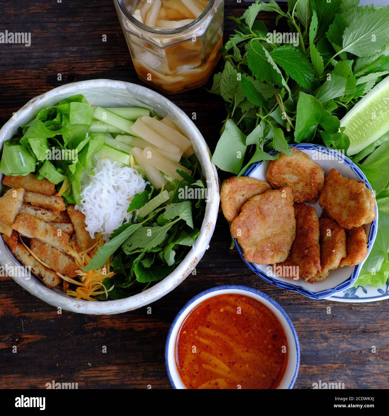 Repas végétarien vietnamien pour le petit déjeuner avec menu de régime, bol de nouilles avec tartes aux champignons frites, salade, sauce à tremper, nourriture végétarienne bonne pour la santé Banque D'Images