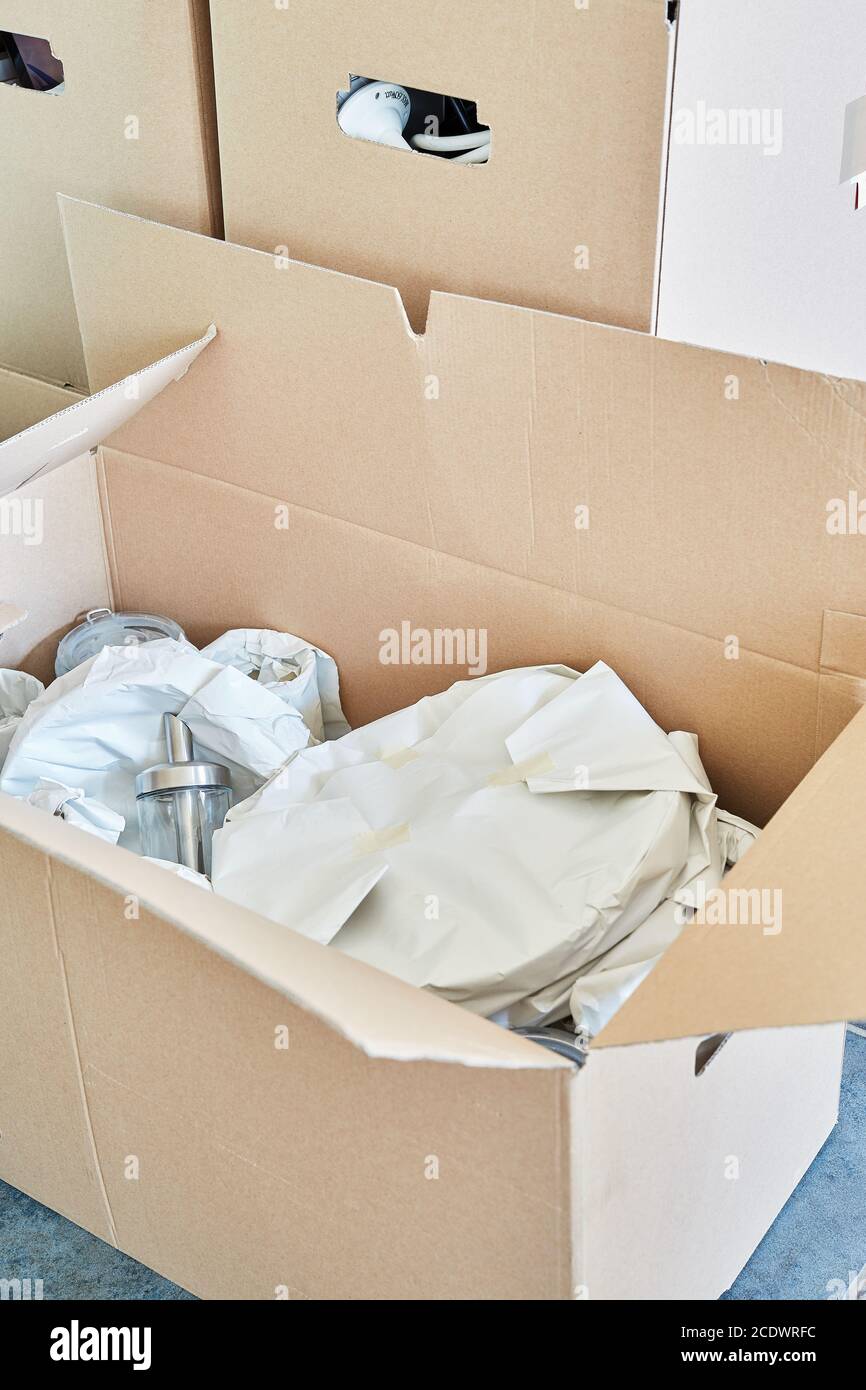 Objets fragiles enroulés dans du papier de soie dans une boîte mobile Banque D'Images