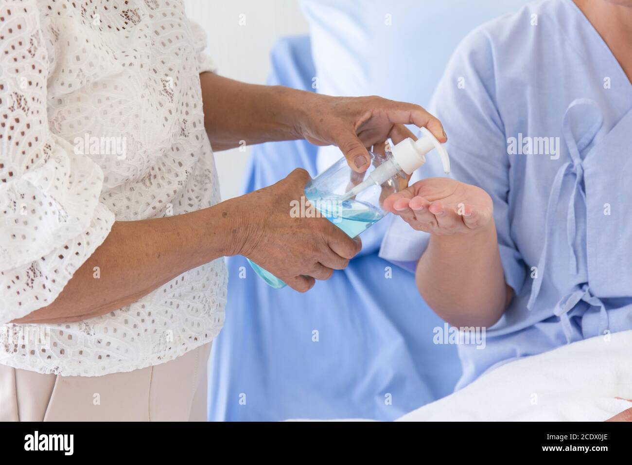 La main qui appuie sur la bouteille de gel d'alcool pour les malades pour se laver les mains. Banque D'Images