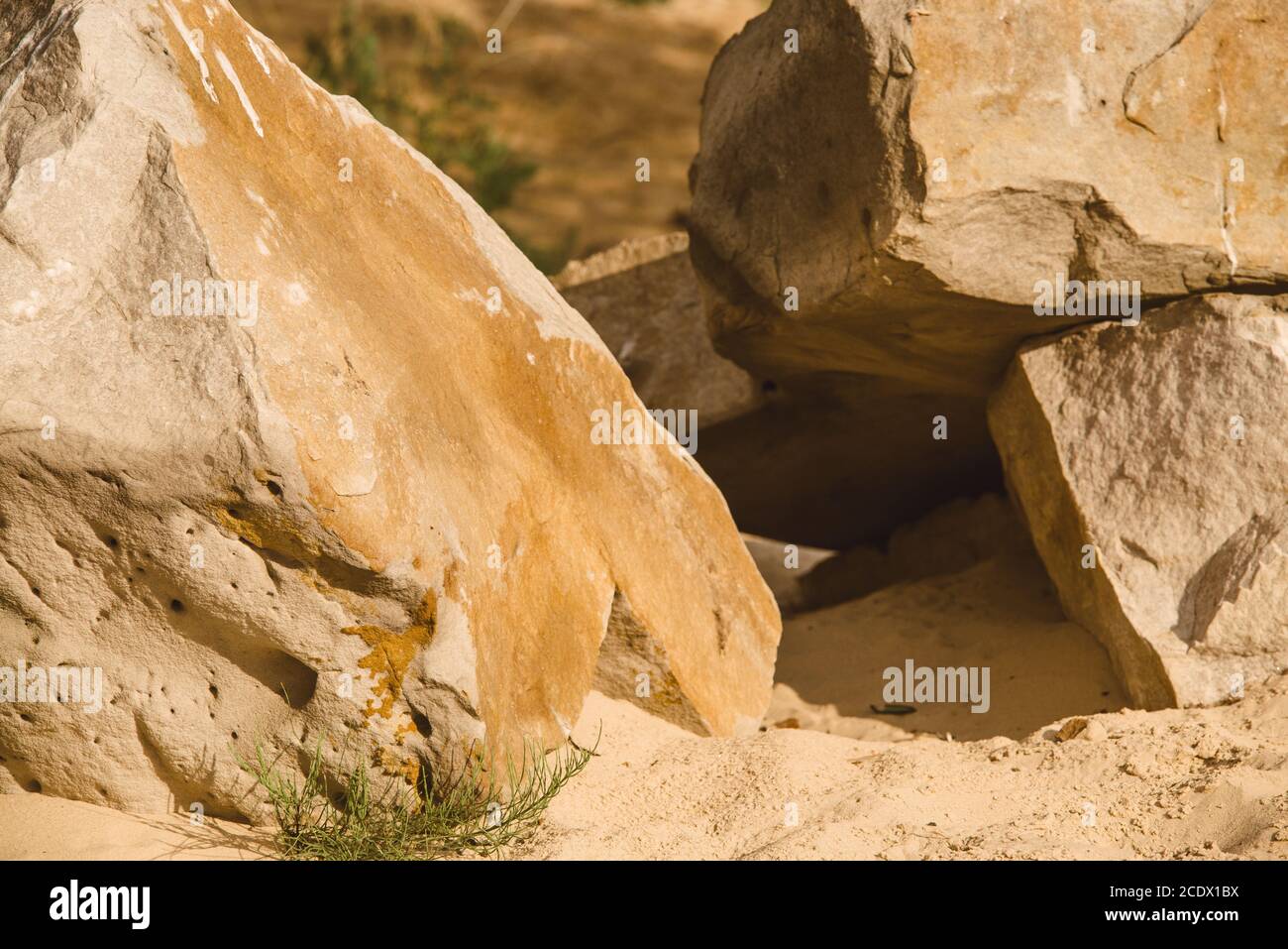 Sable sédimentaires et les roches fissurées sur plage rocheuse de sable avec d'énormes couches de saleté et de poussière de pierre empilés falaise, la texture et le sable Banque D'Images