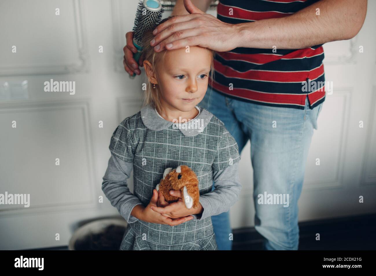 Le père se prépare et aide sa fille à préparer son uniforme à l'école. Banque D'Images