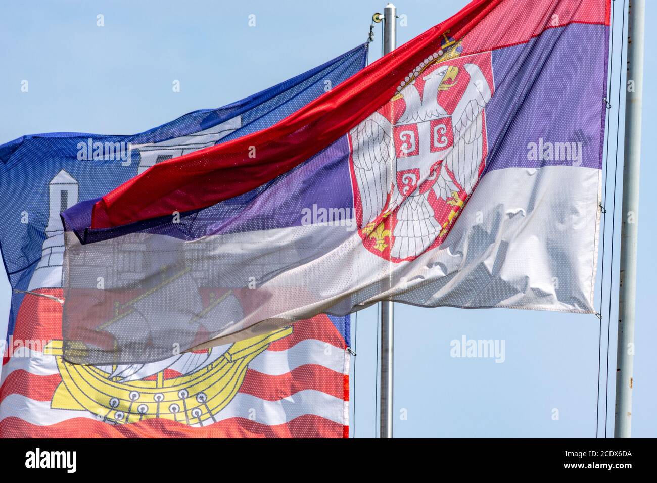 Drapeaux de la République de Serbie et de la capitale serbe Belgrade contre le ciel bleu clair Banque D'Images