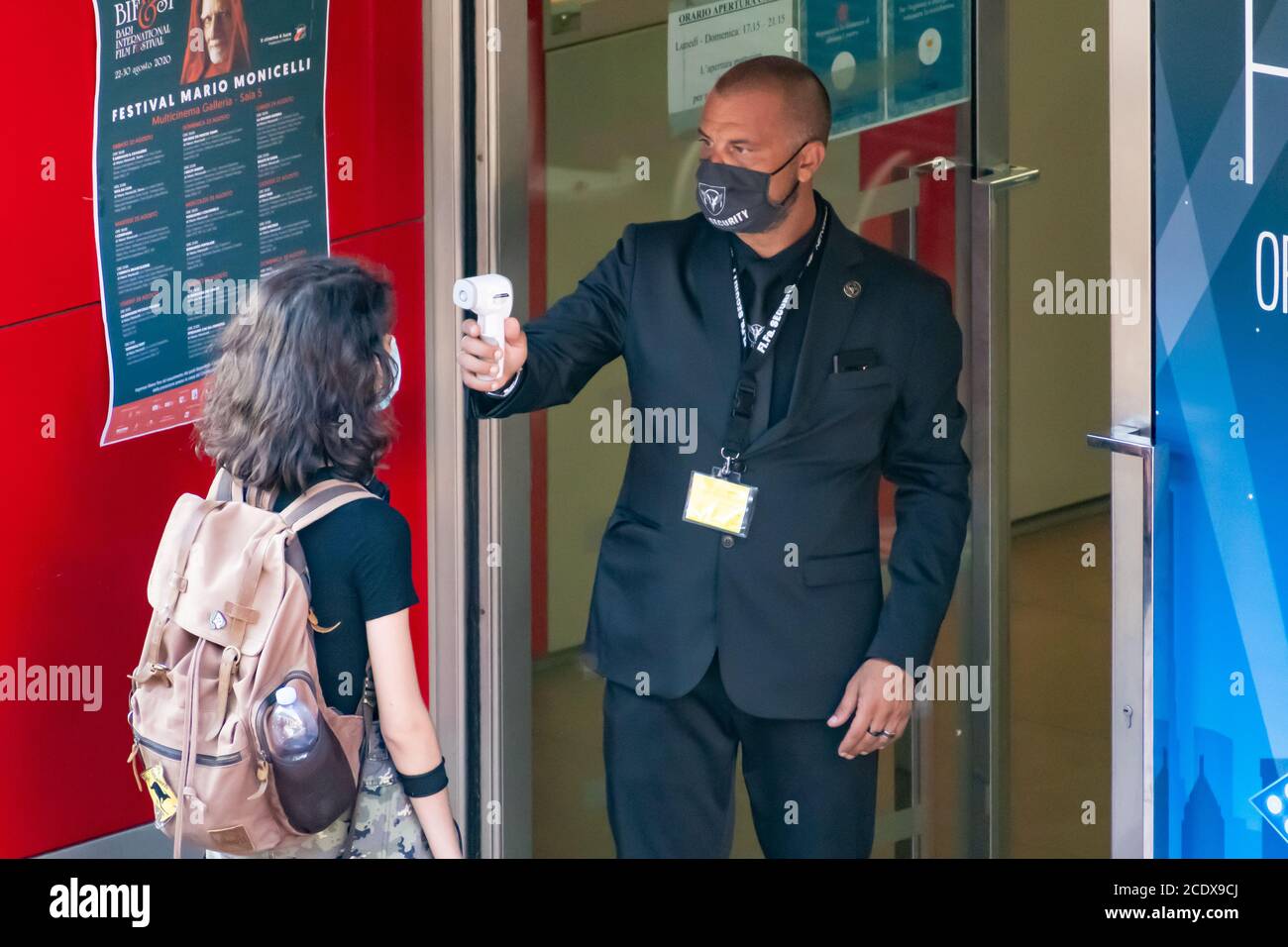 Mesure de la température corporelle à l'entrée d'un cinéma Ou le théâtre pour prévenir la pandémie COVID-19 ou le coronavirus à infrarouge détecteur de fièvre à distance Banque D'Images