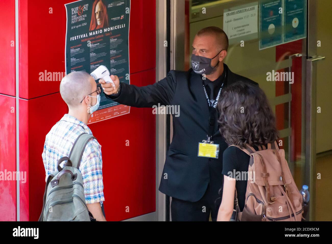 Mesure de la température corporelle à l'entrée d'un cinéma Ou le théâtre pour prévenir la pandémie COVID-19 ou le coronavirus à infrarouge détecteur de fièvre à distance Banque D'Images