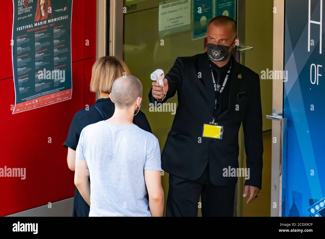 Mesure de la température corporelle à l'entrée d'un cinéma Ou le théâtre pour prévenir la pandémie COVID-19 ou le coronavirus à infrarouge détecteur de fièvre à distance Banque D'Images