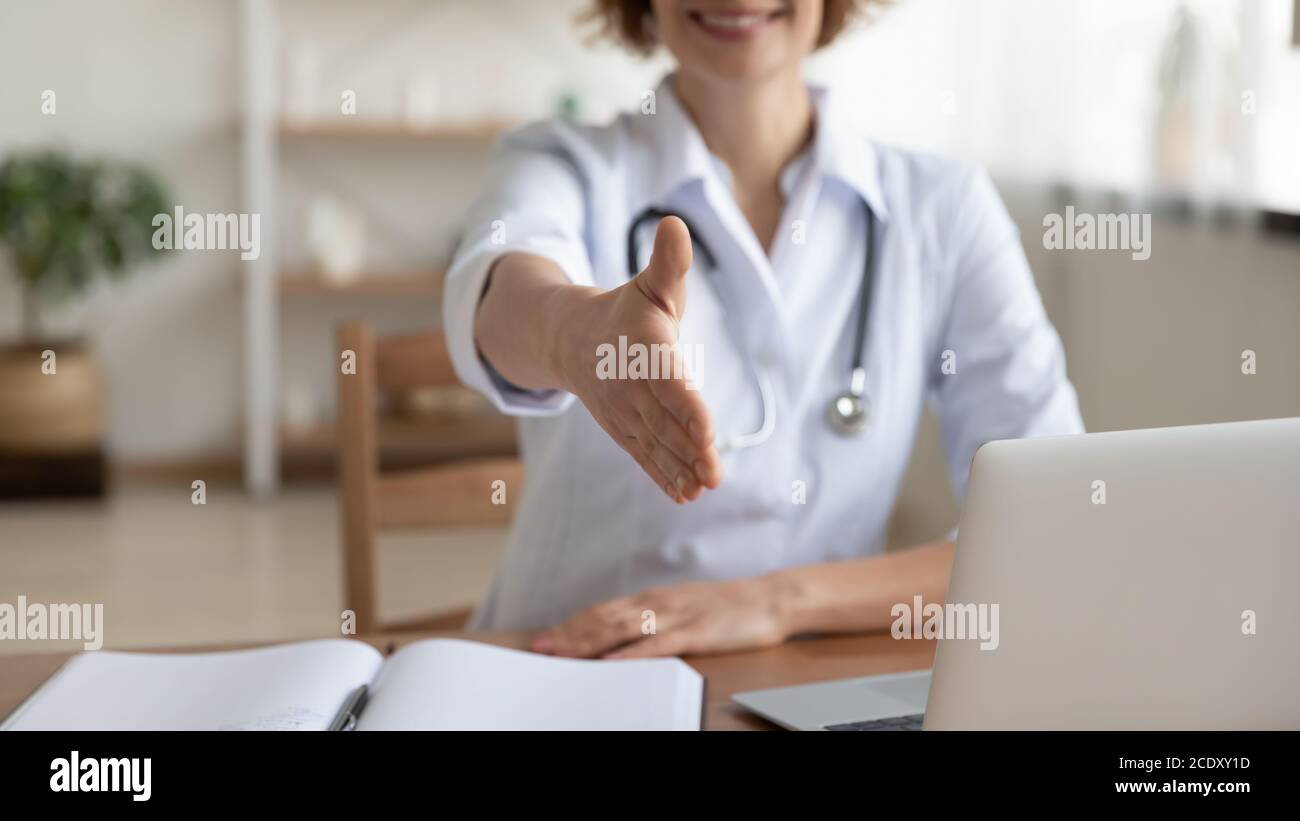 Gros plan femme souriante médecin étendant la main pour la poignée de main Banque D'Images