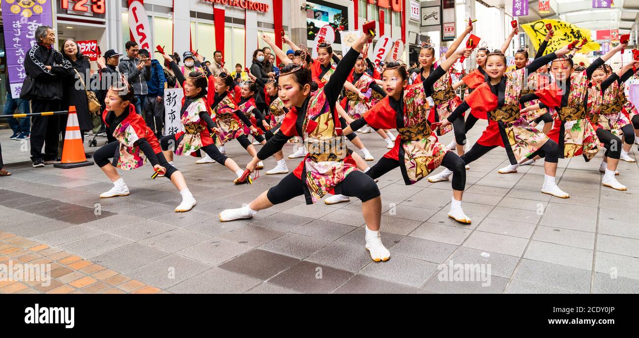 L'équipe japonaise de danseurs de yosakoi enfant tient naruko, des trappeurs en bois, dansant dans la galerie marchande de Sun Road, pendant le festival Kyusyu Gassai. Banque D'Images