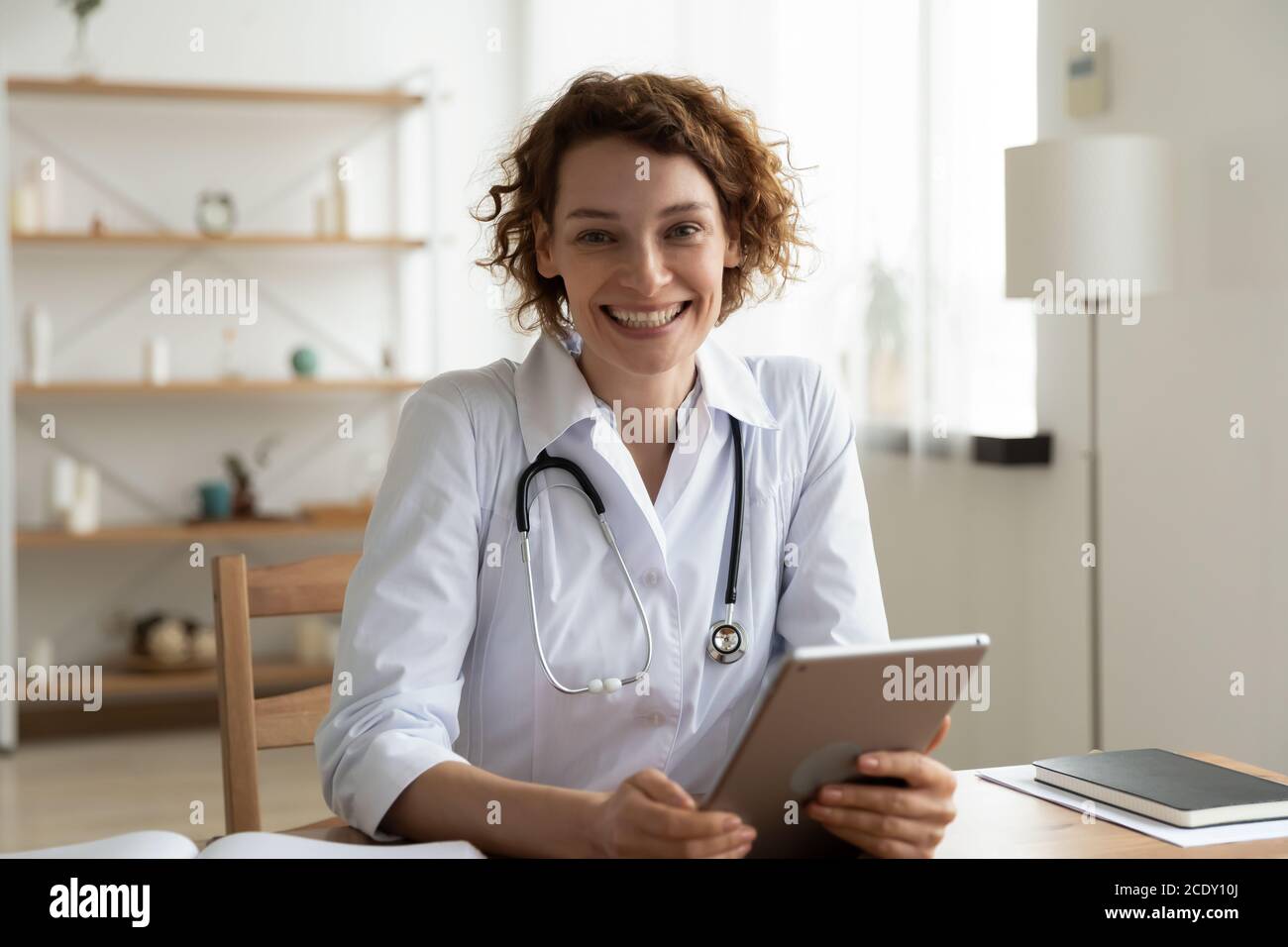 Tête prise de vue portrait femme souriante médecin tenant une tablette numérique Banque D'Images
