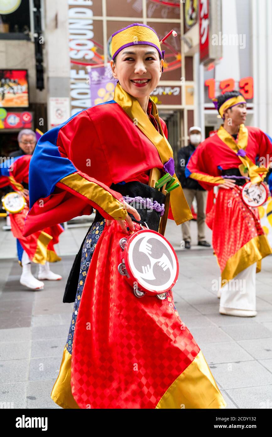 Gros plan d'une femme japonaise mûre, faisant partie d'une équipe de danse de yosakoi, dansant avec le tambourin pendant le festival Kyusyu Gassai à Kumamoto au Japon. Banque D'Images