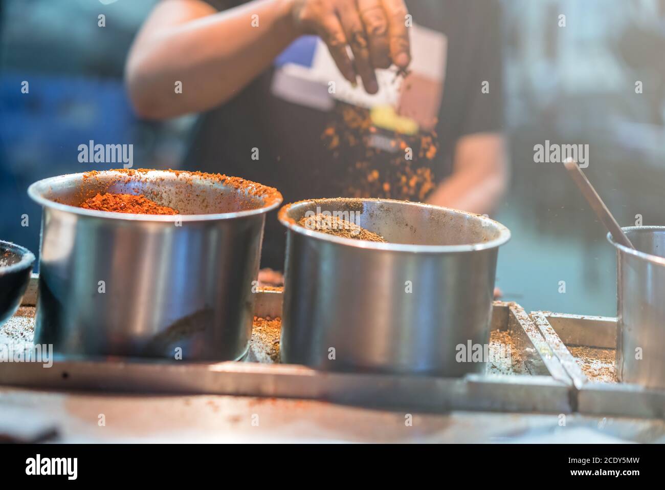 Chef chinois ajoutant des épices à la nourriture Banque D'Images