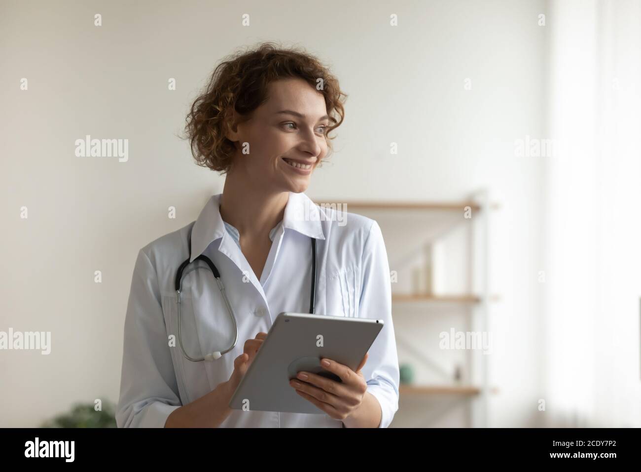 Gros plan femme souriante médecin tenant une tablette numérique, réfléchir à des idées Banque D'Images