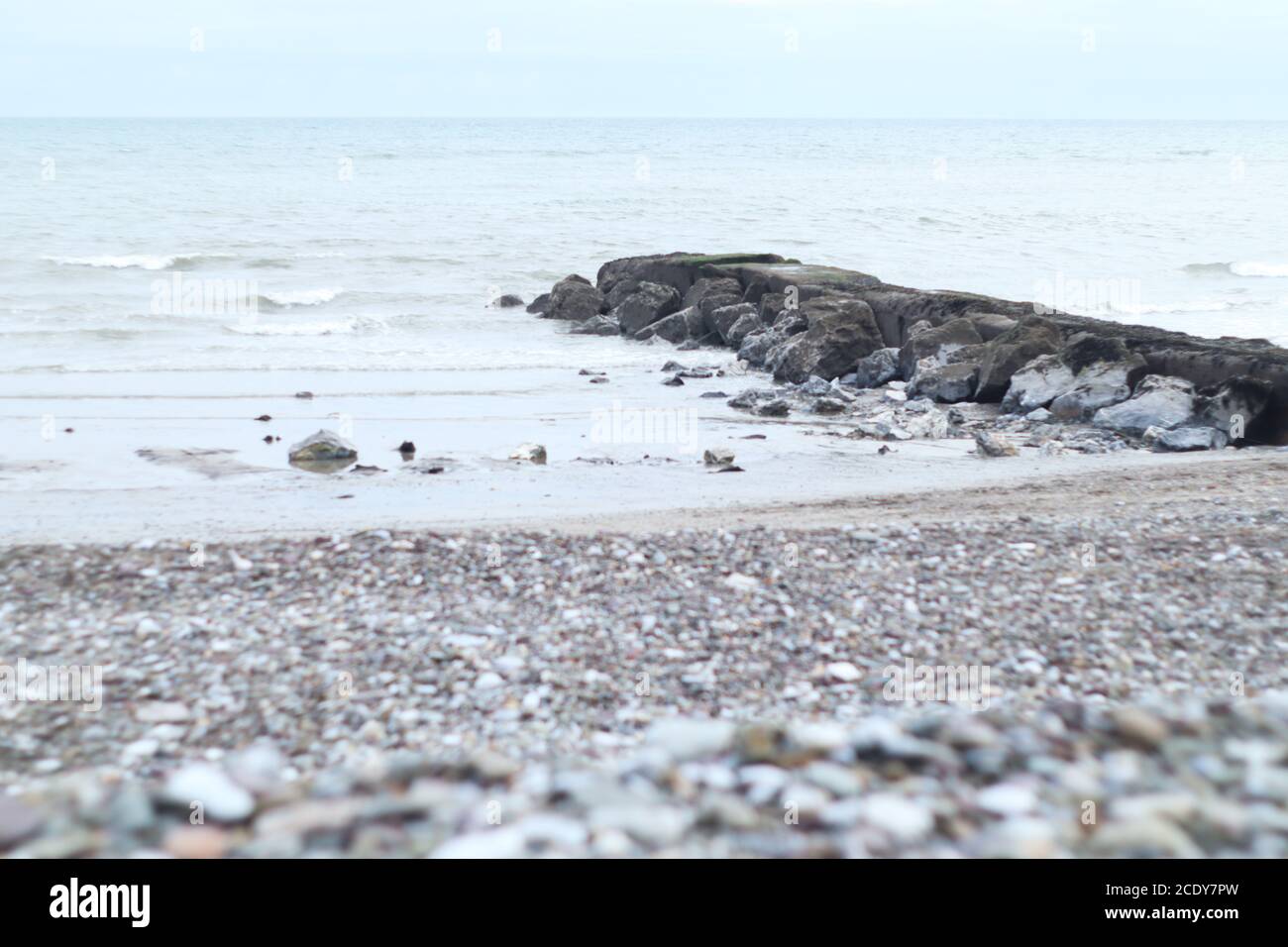 Garryvoe Beach Landscape Cork Ireland - Stony Pier Sea Stones Bleu clair naturel High Key Beach Seascape - Horizon et Courbes en vue Banque D'Images